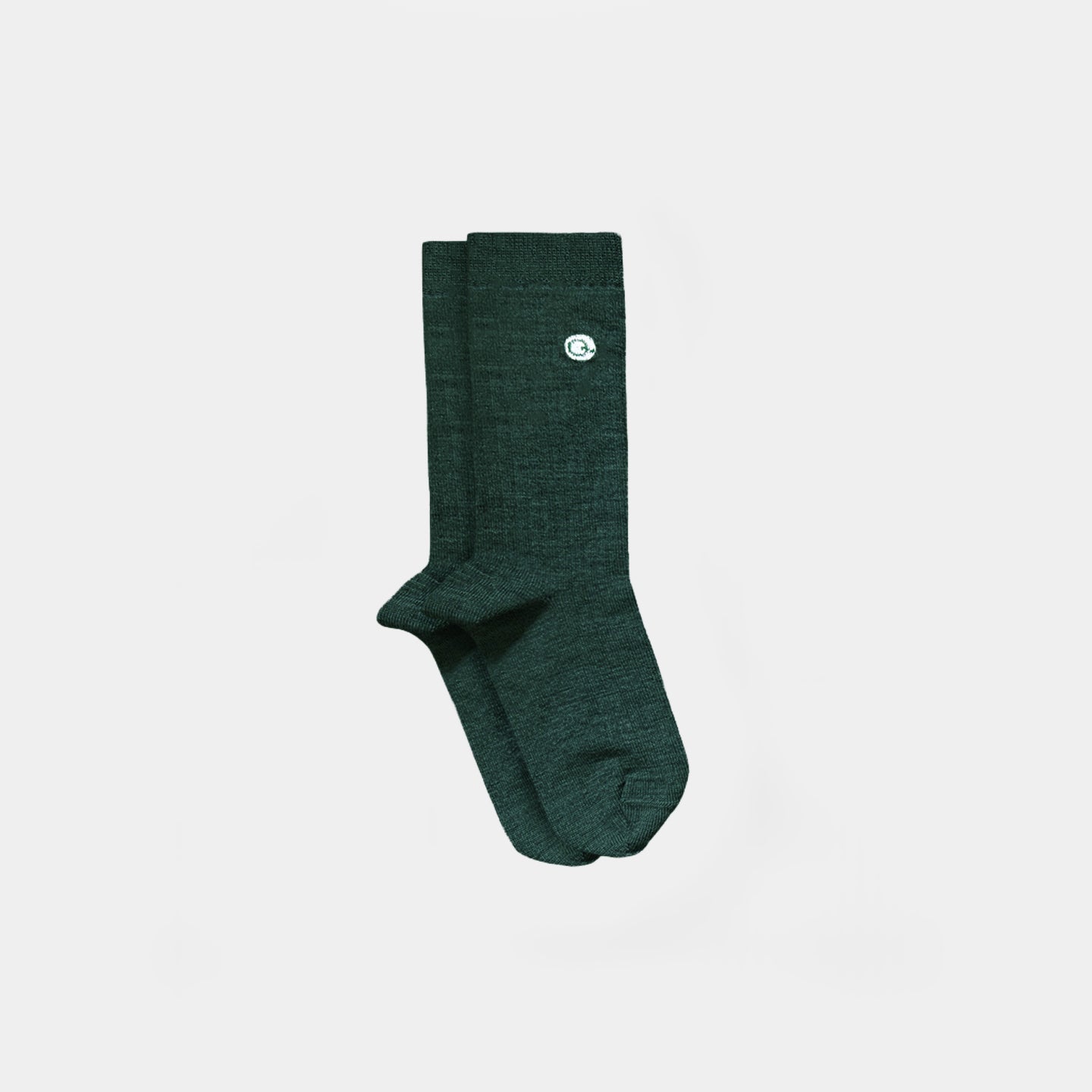 A pair of dark green heathered crew socks with a small white circular logo on the upper cuff, displayed against a solid light gray background.