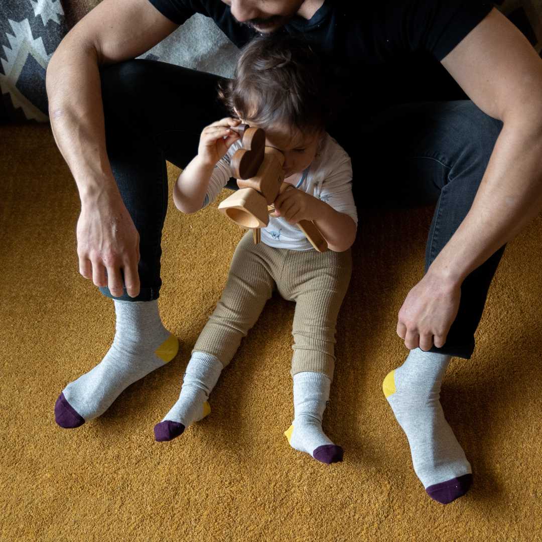 Father and daughter wear shades of grey socks