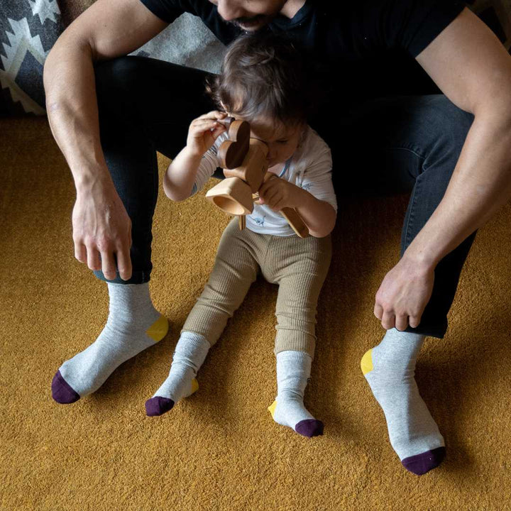 Father and daughter wear shades of grey socks
