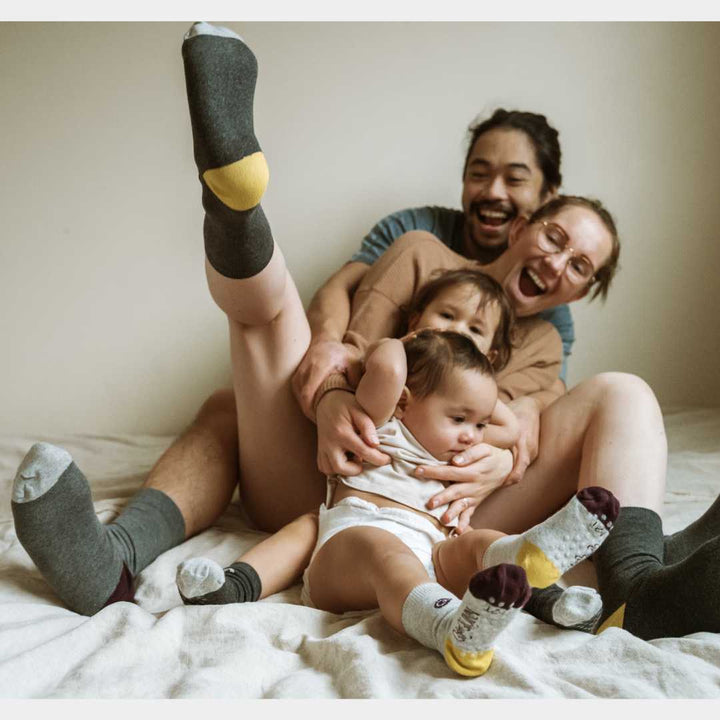 A family laughing and wear matching family organic socks