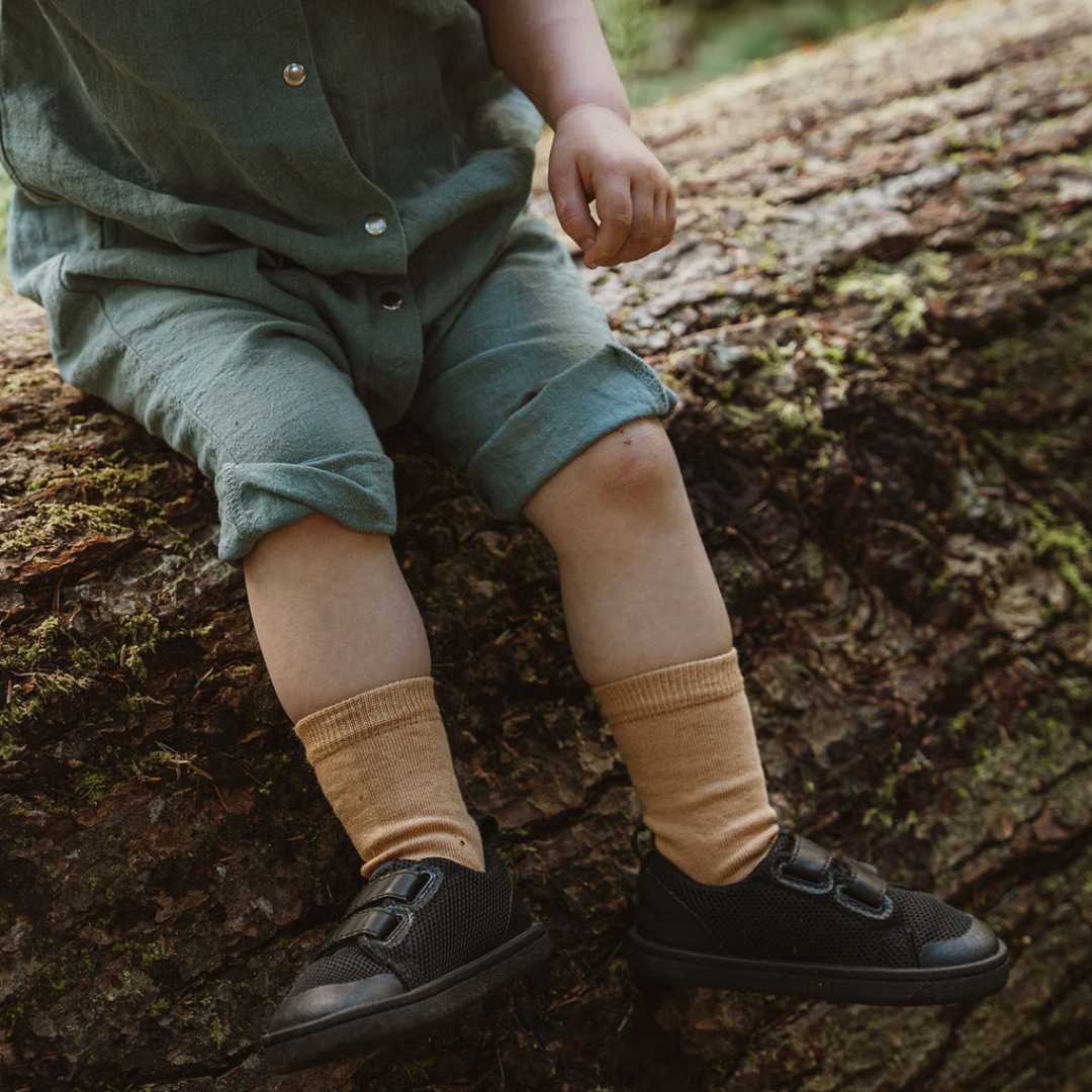 Kid Sitting Down Wears Organic Cotton Socks