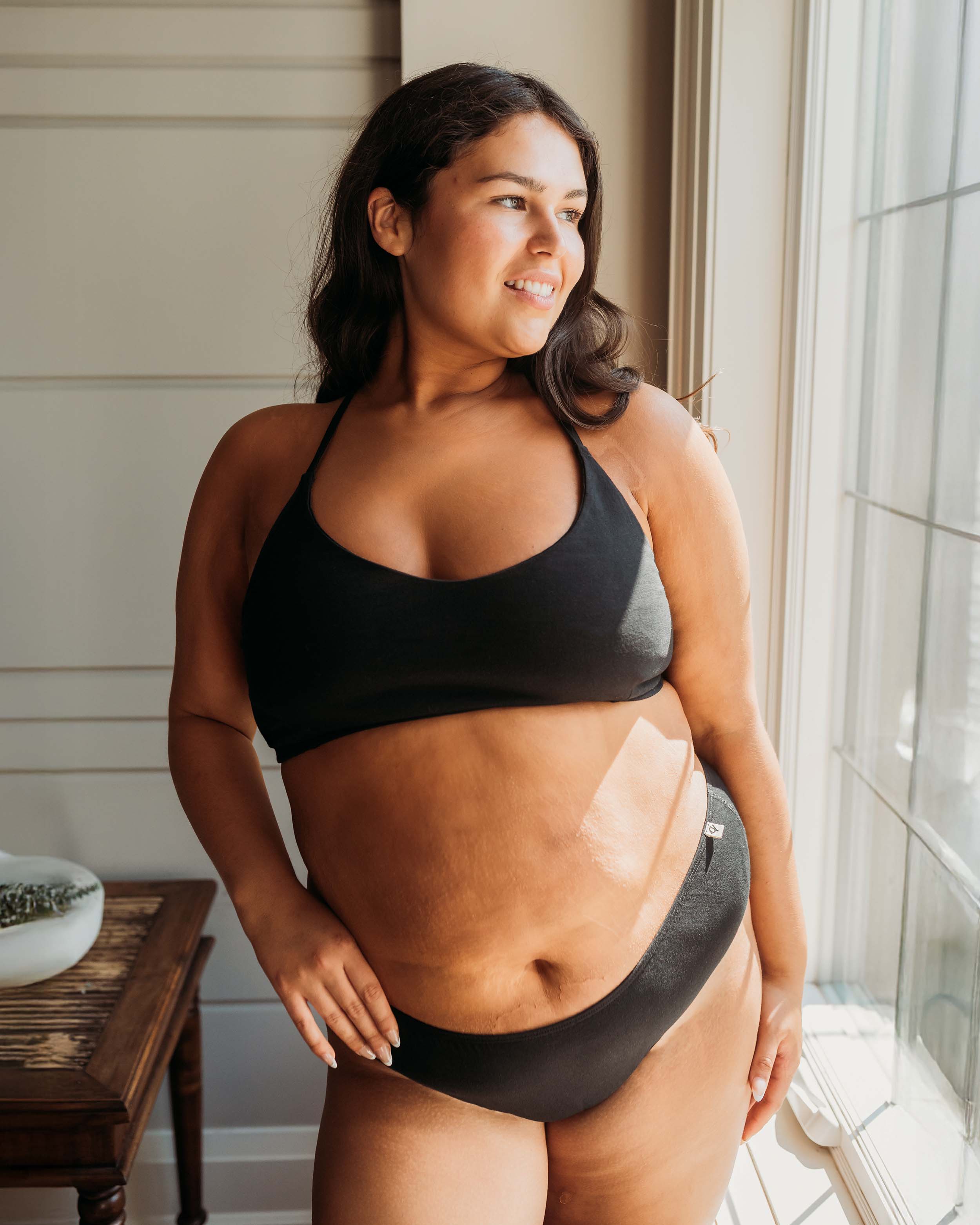 Model near sunlit window wearing Womens Classic Brief in Black | Q for Quinn