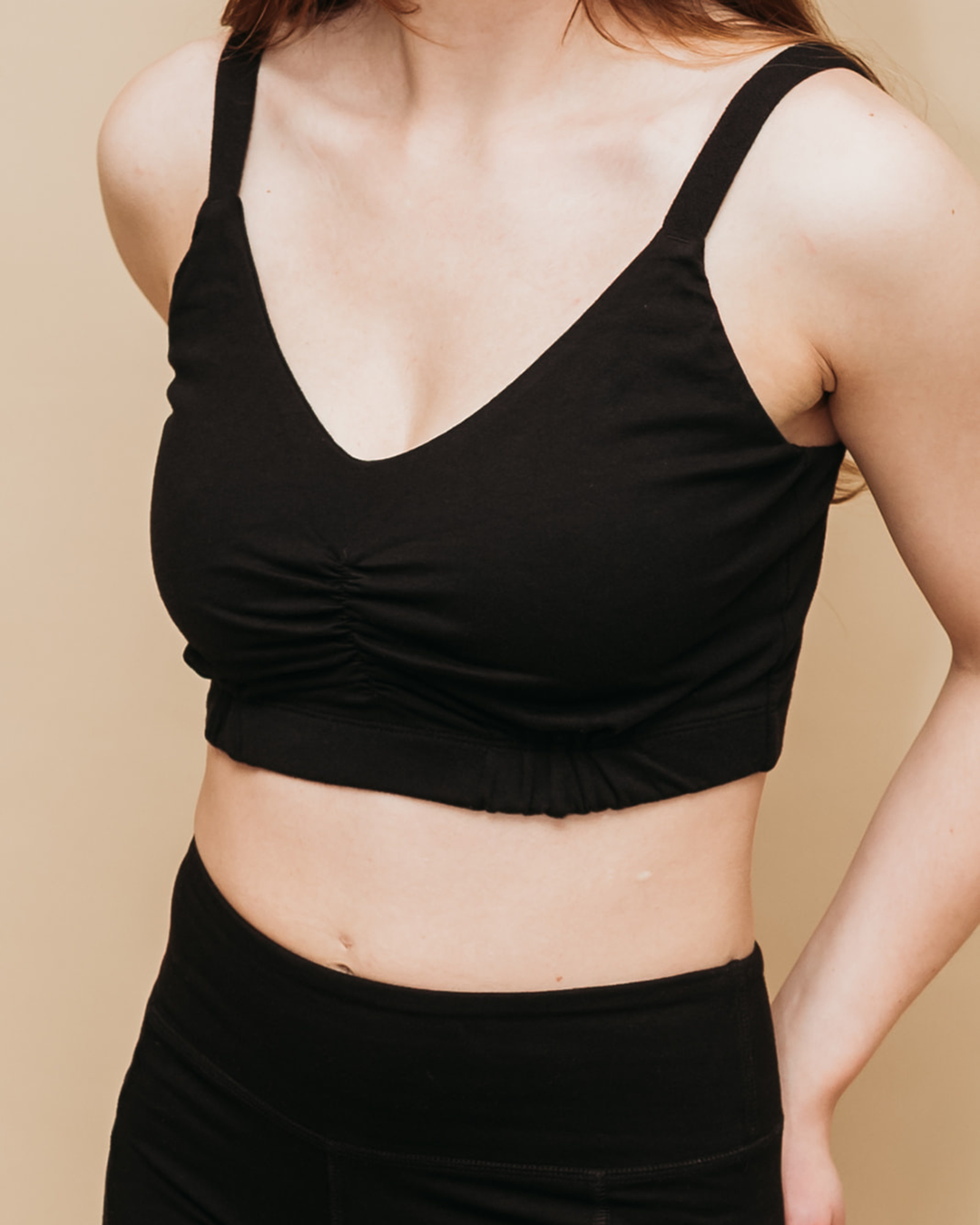 Black tank top worn by a person on a beige background
