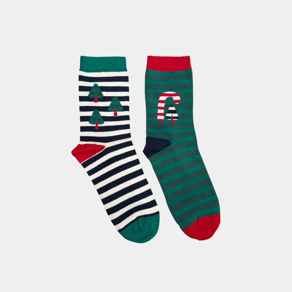 A pair of Christmas-themed crew socks on a light gray background. One sock has navy and white horizontal stripes with green Christmas tree motifs and a red toe.