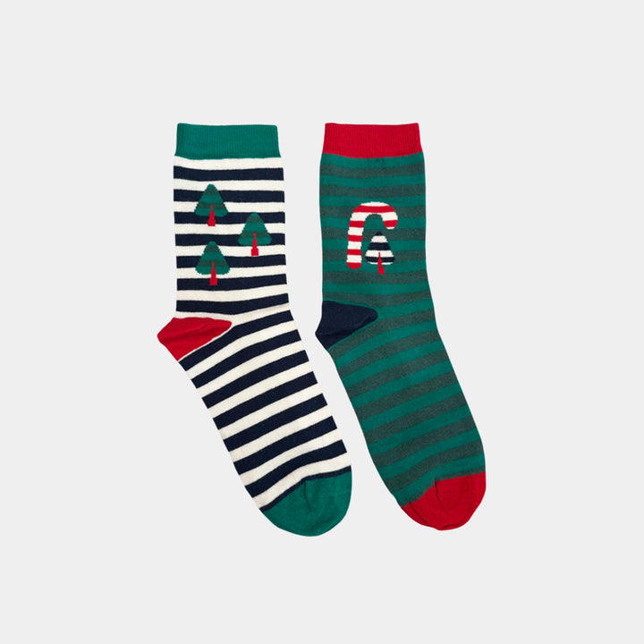 A pair of Christmas-themed crew socks on a light gray background. One sock has navy and white horizontal stripes with green Christmas tree motifs and a red toe.