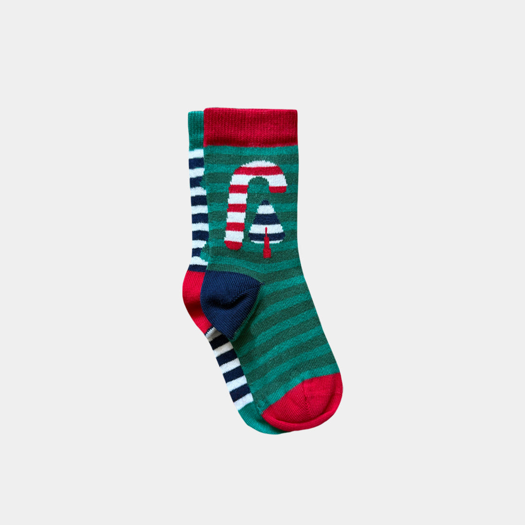 A pair of Christmas-themed crew socks featuring a green and teal striped pattern, a red cuff, a red toe, and a navy heel. One sock displays a large white letter 'C' with red and white diagonal stripes resembling a candy cane.