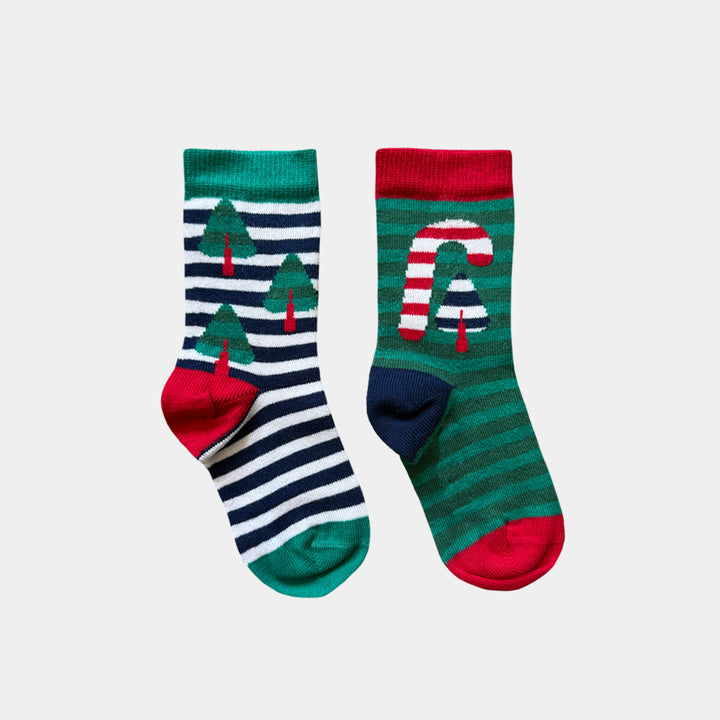 A pair of Christmas-themed crew socks on a light gray background. One sock features navy and white horizontal stripes with green Christmas trees and a red toe/heel.