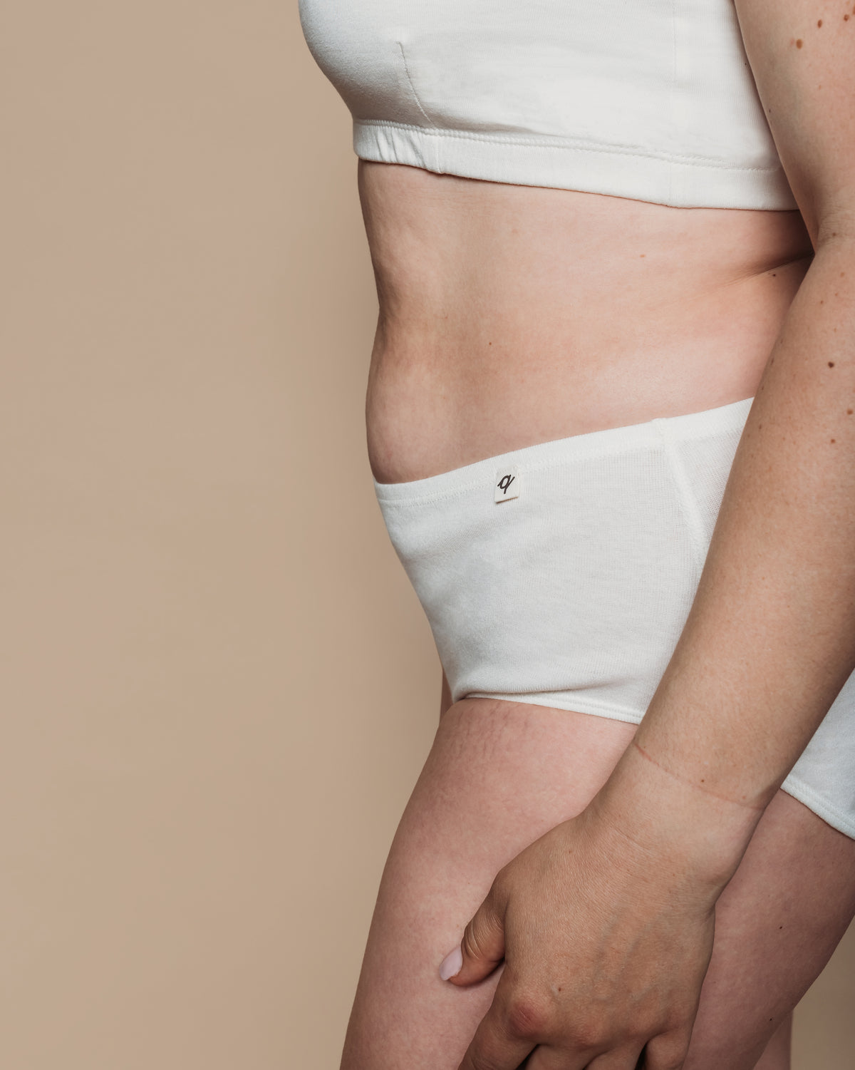 Side view of woman wearing undyed white organic cotton boyshort briefs | Q for Quinn