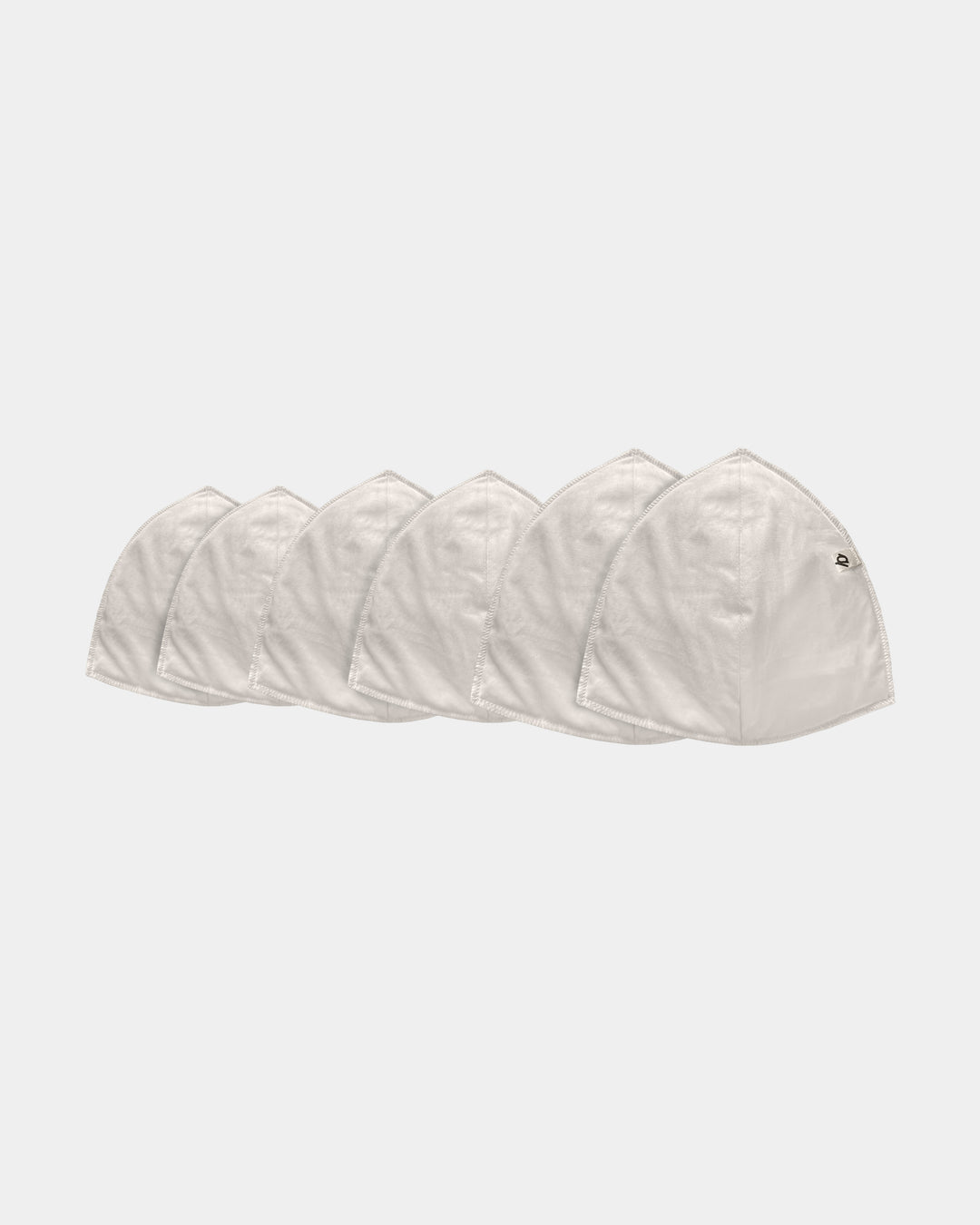 Five light beige fabric face masks arranged in a row on a plain light gray background.