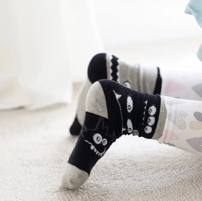 Kid wearing black and grey 'Monochrome Monsters' socks | Q for Quinn