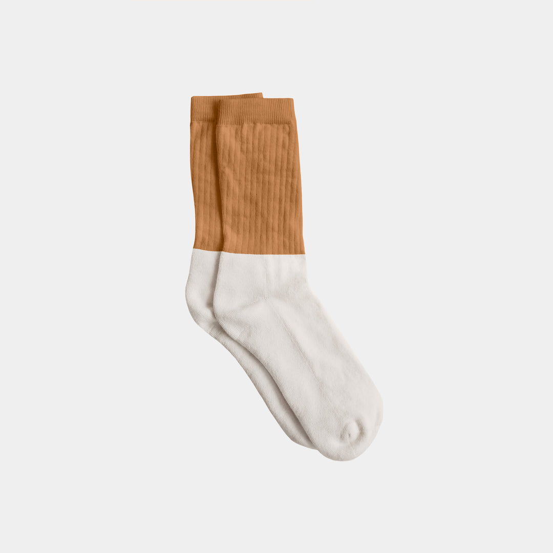 Sock with brown top and white bottom on a light gray background