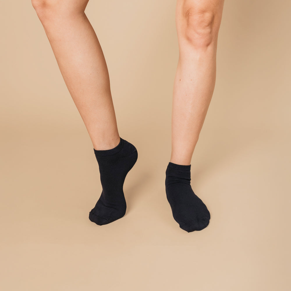 Navy blue organic cotton ankle socks worn on adult legs against beige background | Q for Quinn