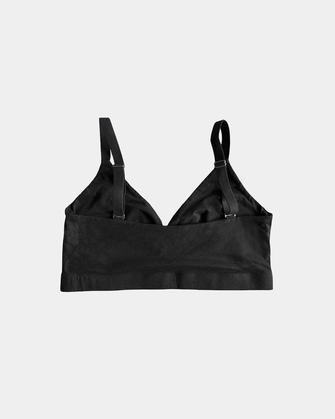 Black bralette with thin straps on a light gray background