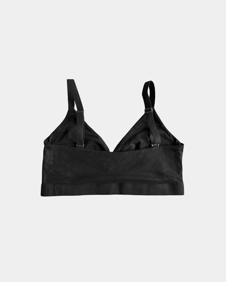 Black bralette with thin straps on a light gray background