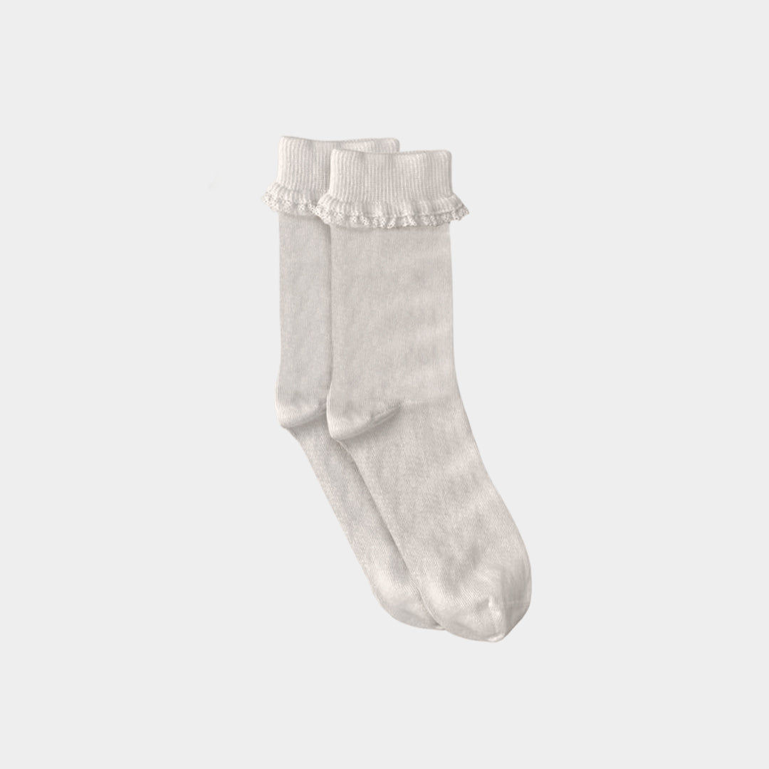 A pair of off-white ribbed ankle socks with delicate ruffled trim at the top, displayed against a solid light gray background.