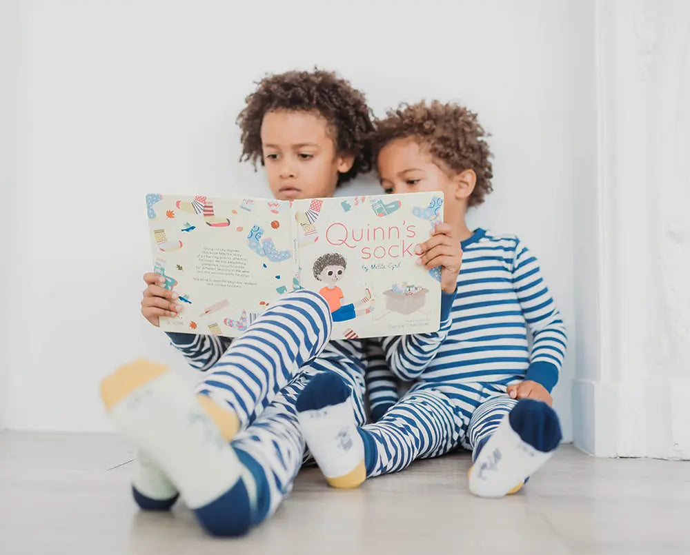 2 boys reading a book, wearing striped pyjamas, organic cotton