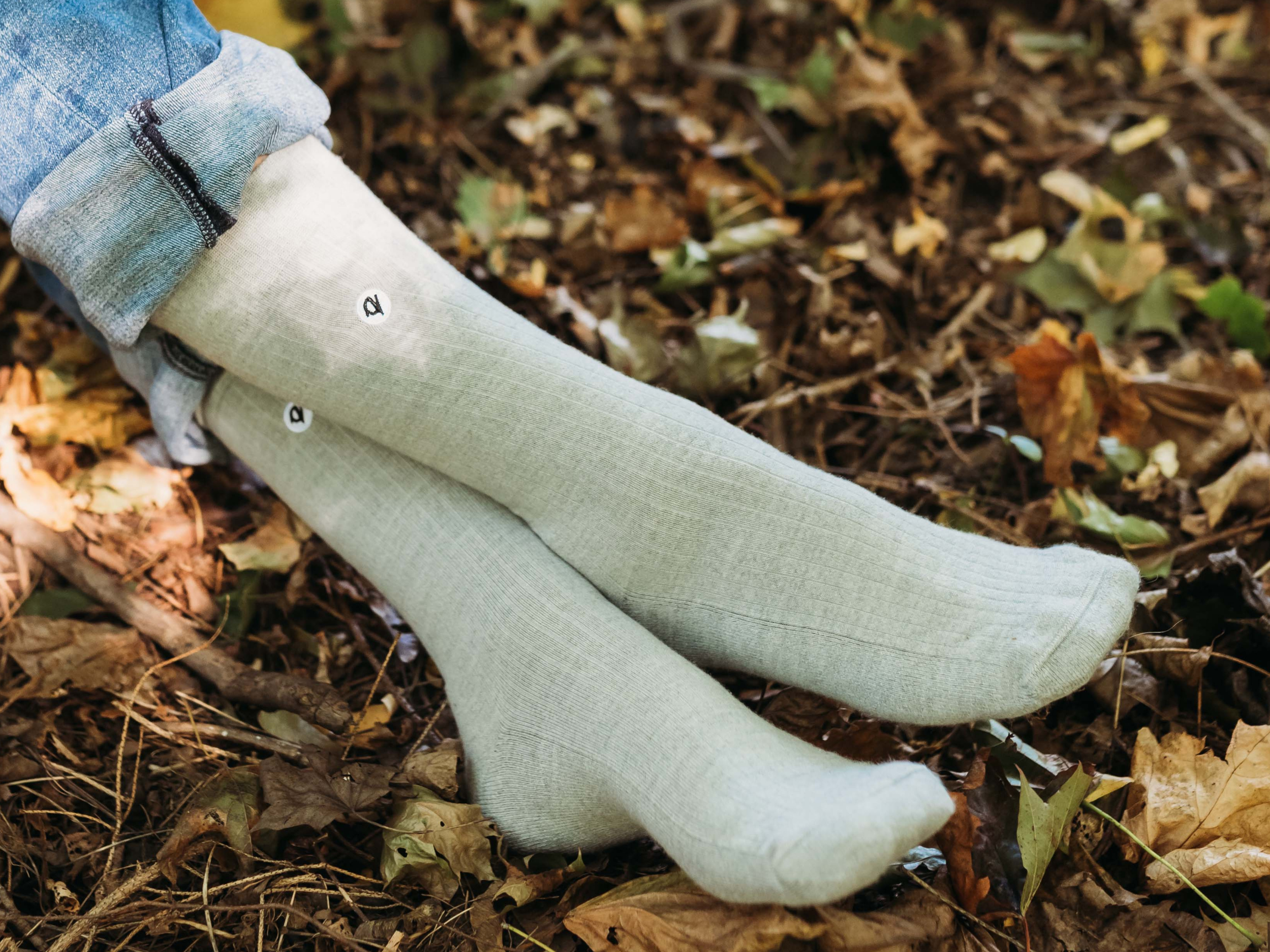 White socks worn outdoors on a leaf-covered ground