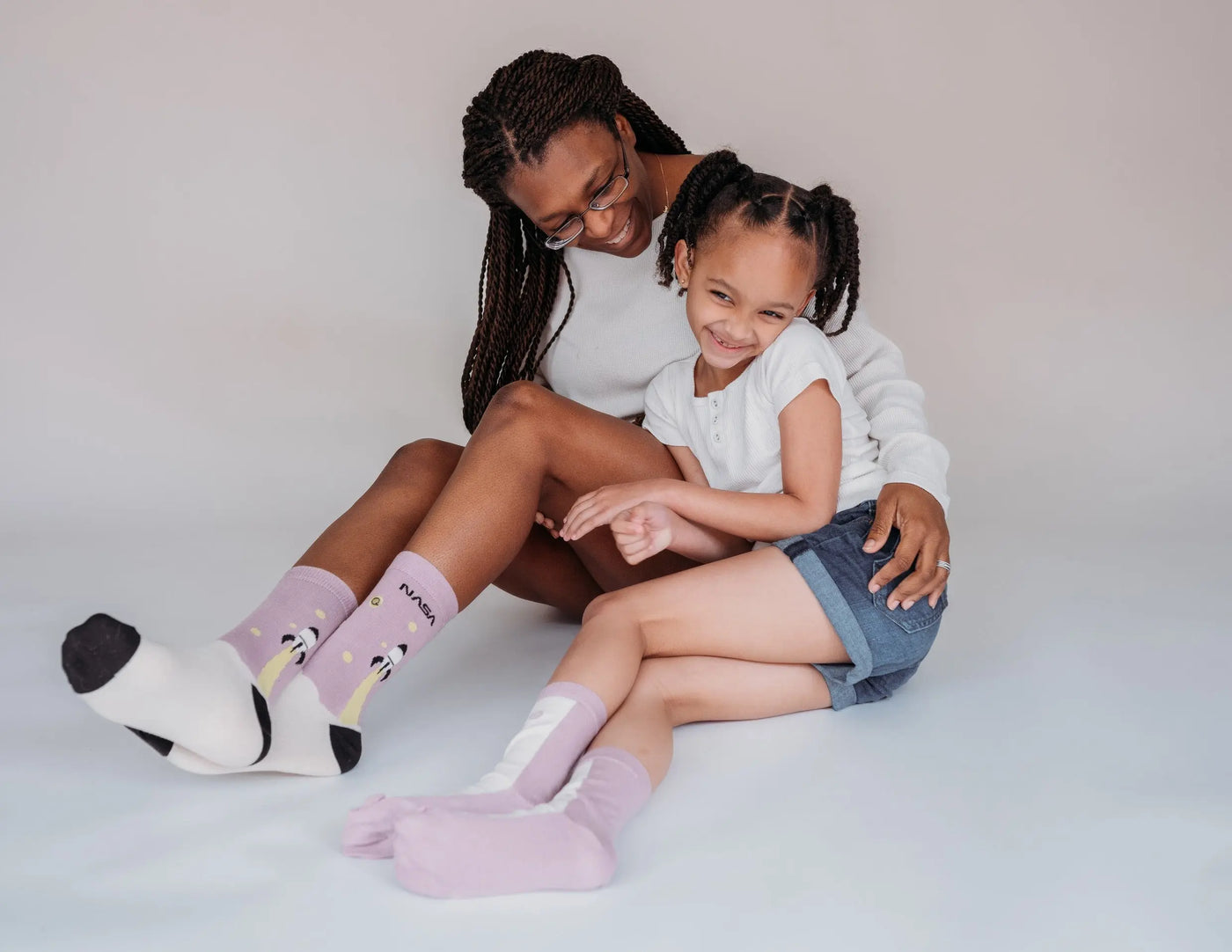 Mother and daughter smiling wearing  matching colour socks  