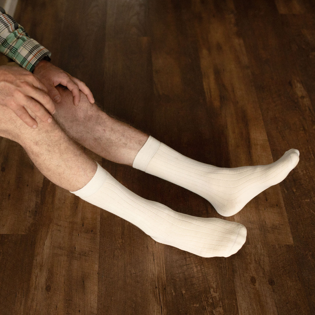 Pure (no dye) Heavyweight Organic Cotton Adult Socks worn on bare legs, seated on wood floor | Q for Quinn