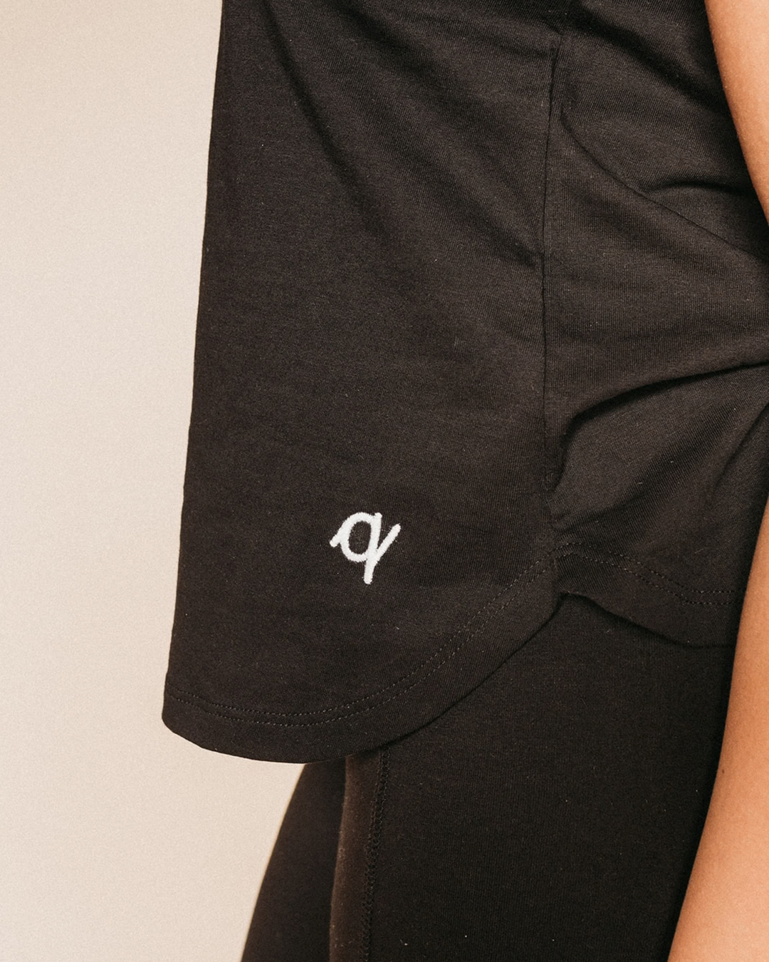 Black shorts with a white logo on a beige background