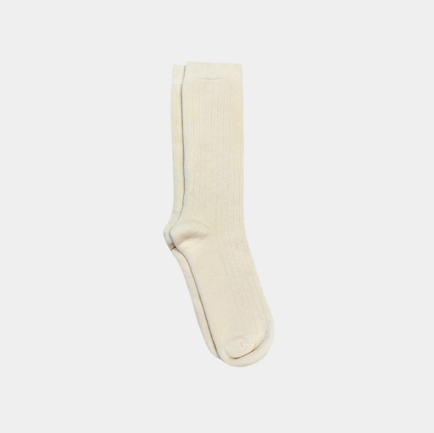 White knee-high sock on a light beige background
