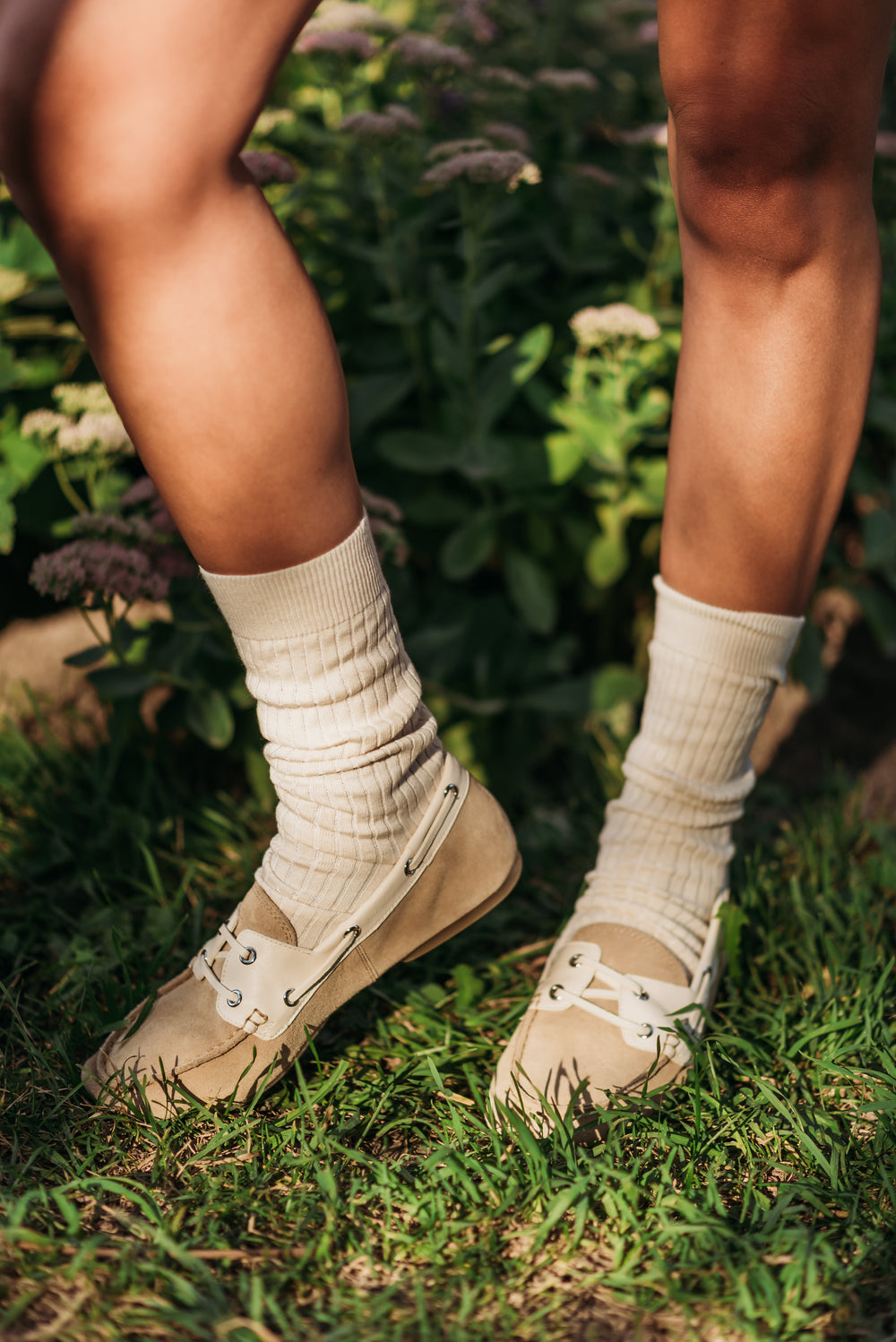 Cream ribbed organic cotton crew socks styled with beige boat shoes on grass | Q for Quinn